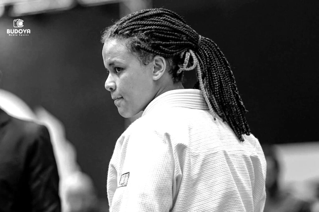 Foto da Manu, competidora de jiu-jitsu usando um kimono Tasu branco.